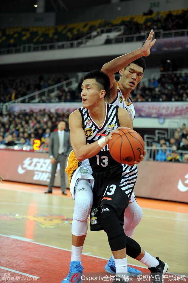 赵继伟受伤倒地后，表情痛苦地捂着自己的腿部，身边的队友和对手都纷纷举手示意，场边担架已准备好，现场气氛凝重。