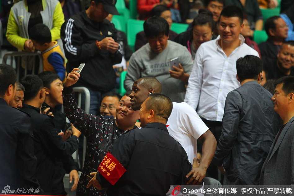 哈德森挤出人群与忠实球迷合影，闪光灯亮起记录下这珍贵的追星时刻