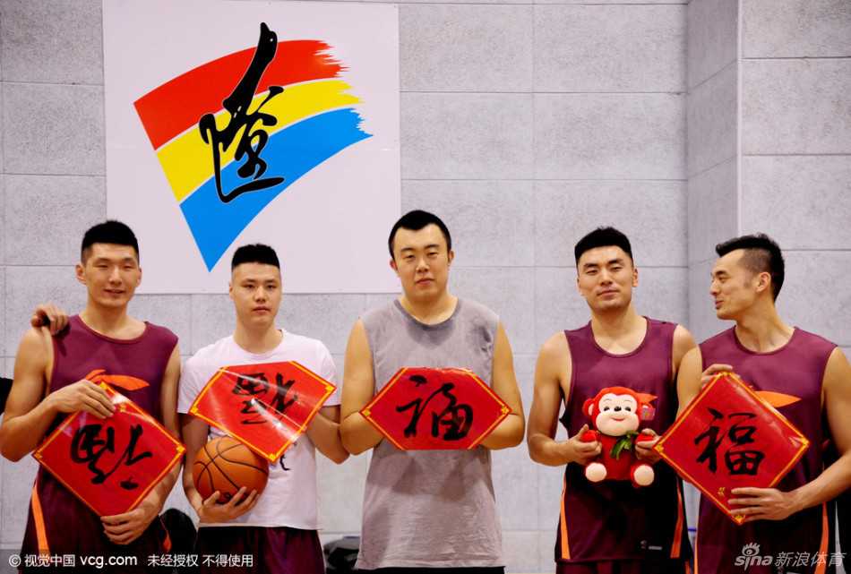 郭艾伦手持红色新春卡片，对着镜头俏皮地眨眼，左侧鬓角的13号发型清晰可见，笑容里透着一股大男孩的顽皮与自信。