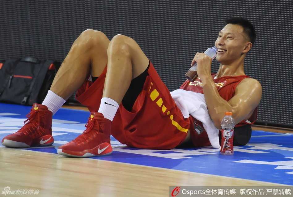 男篮核心易建联在训练间隙神情放松，面带微笑与队友交流，展现出了球队领袖的沉稳与自信