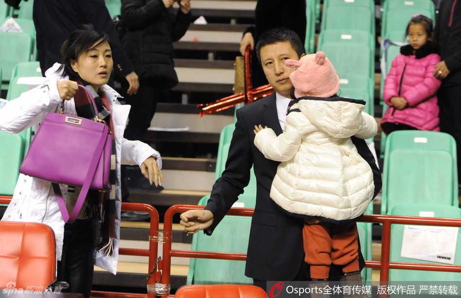 郭士强女儿穿着可爱的童装，小脸蛋肉嘟嘟的，表情萌萌地趴在父亲肩头，小手紧紧抓着父亲的衣服