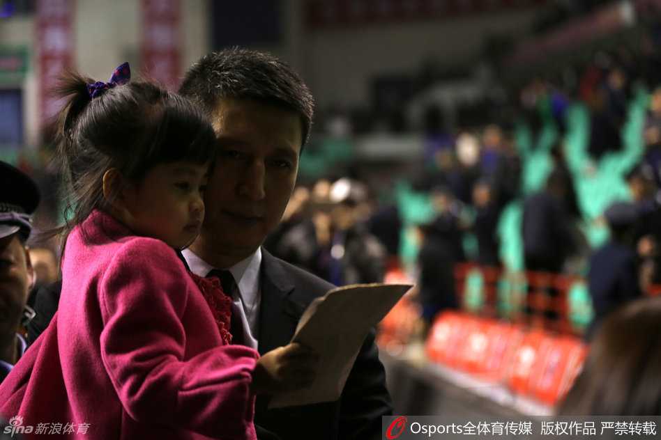 离场时刻，小家伙在爸爸怀里开心地手舞足蹈，郭士强被逗得开怀大笑，身后的喧嚣赛场成了他最温馨的背景板。