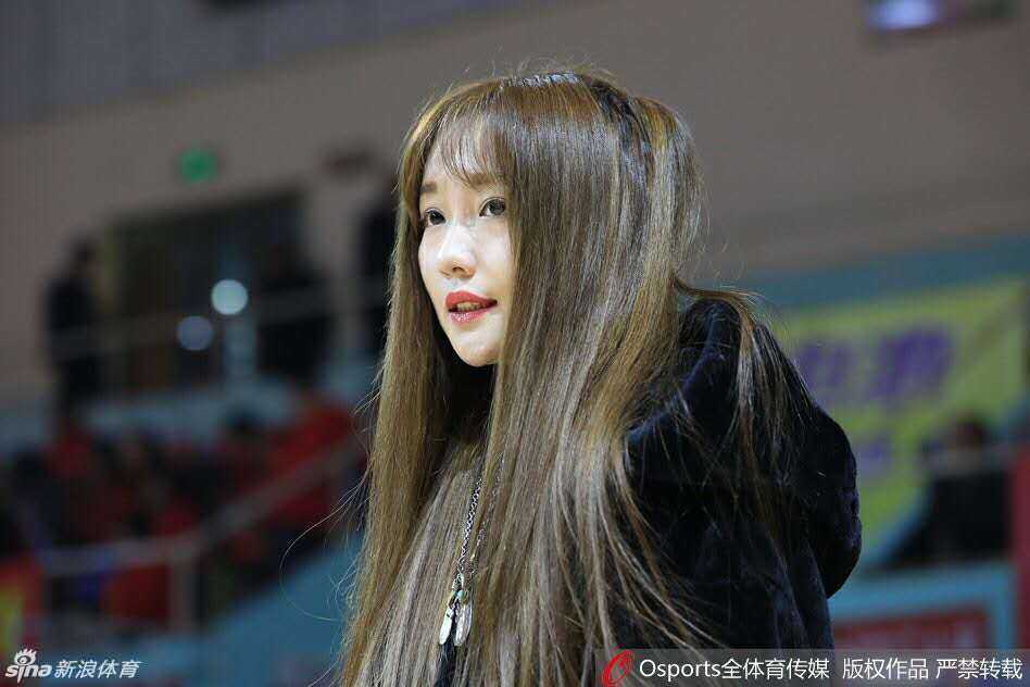 比赛进入白热化阶段，八一队比分落后，女球迷神情紧张，双手紧握置于胸前，全神贯注地注视着场上的每一次攻防，眼神中透露出对球队的无限关切与期待。