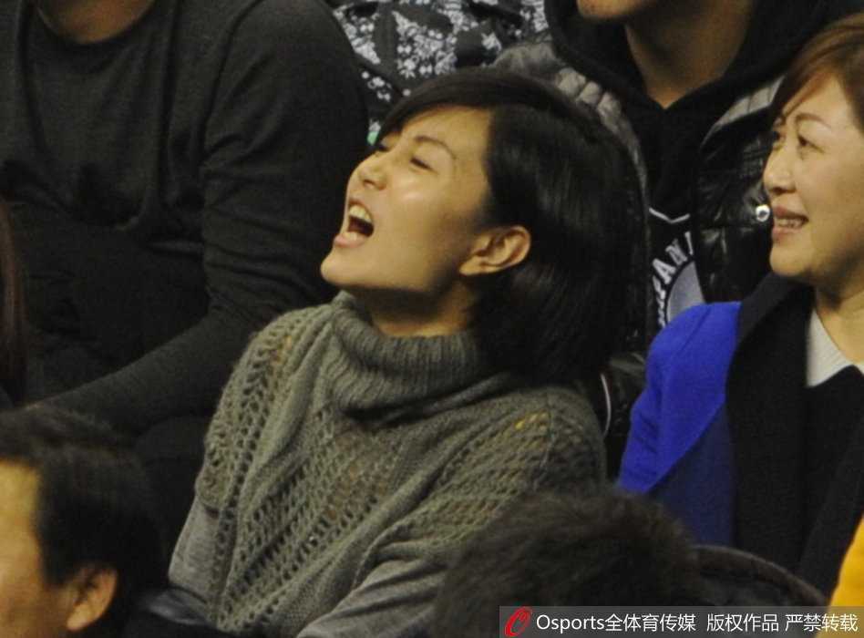 唐佳良兴奋地指向场内，似乎在告诉身边的伙伴：“快看，我看到他了！”那是一种无法掩饰的自豪与喜悦，仿佛整个球馆的灯光都汇聚于此。