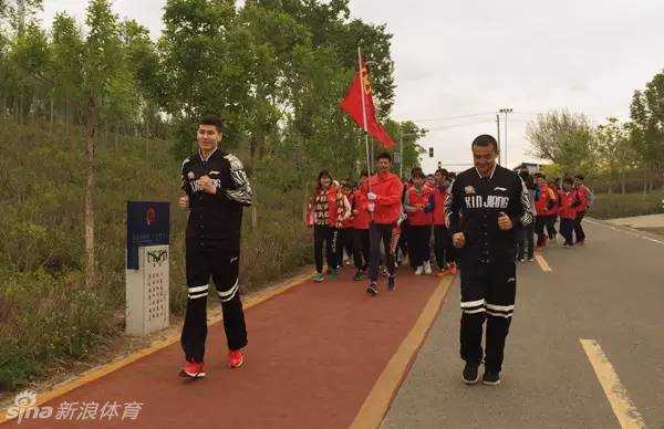 西热力江与阿不都沙拉木冒雨领跑，两人步伐矫健，引领着身后的公益跑大部队向前进发。