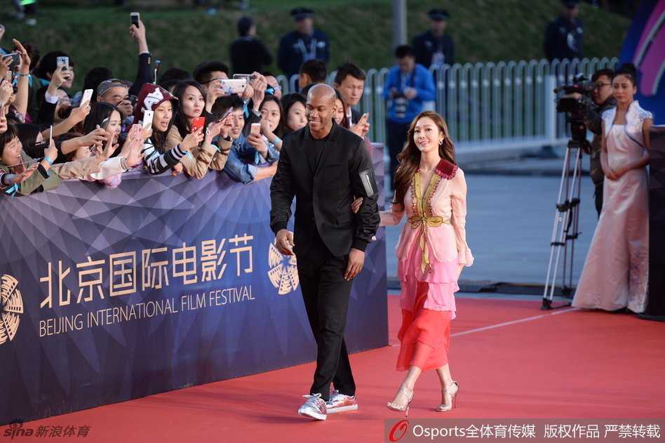 镜头前的郑秀妍回眸一笑，长发披肩，粉色的礼服裙摆随着她的步伐轻轻摆动，在北影节的红毯上留下一道靓丽的风景线。