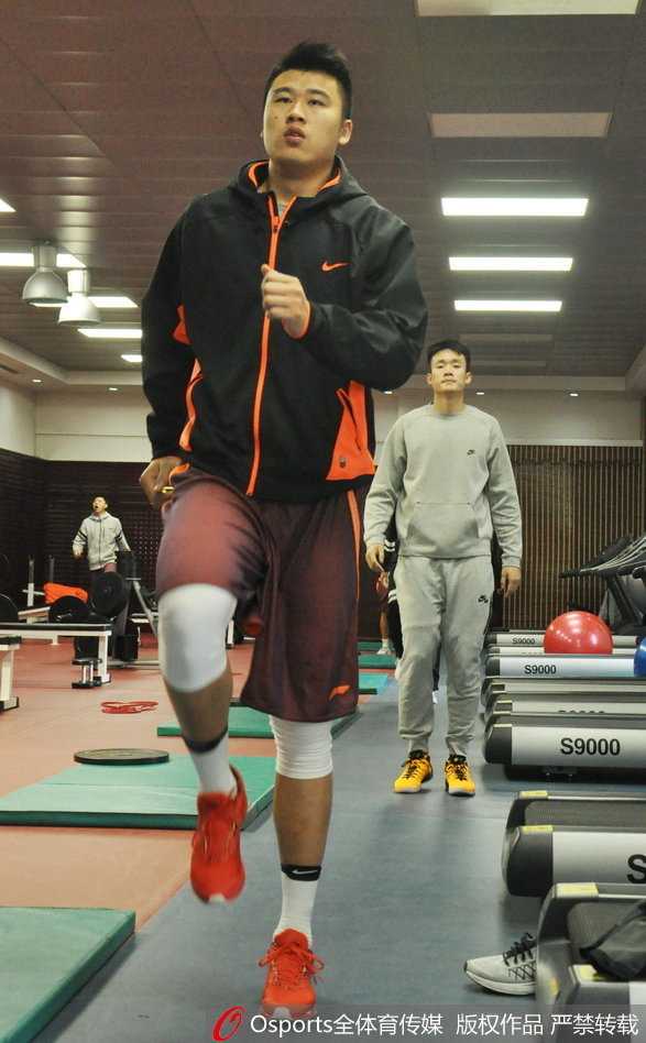 山东男篮全队在健身房集结，在体能教练的口令下进行整齐划一的拉伸，团结的氛围在每一次伸展中凝聚。