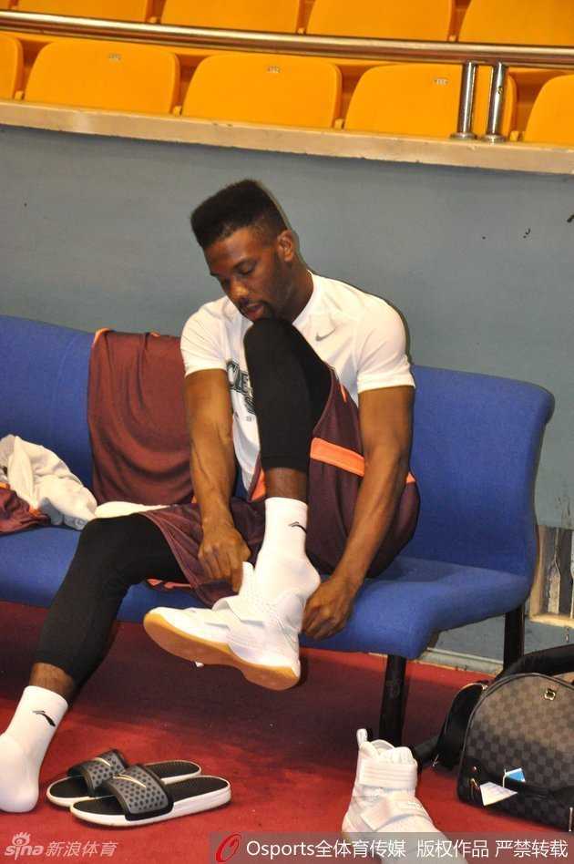 大外援汤普森低头弯腰，认真整理着自己的球鞋和护具。他从不是最耀眼的那颗星，但总是最早来到场地、最晚离开的那一个，换上装备的瞬间，他切换到了“工作模式”，准备为山东队守护每一寸禁区。