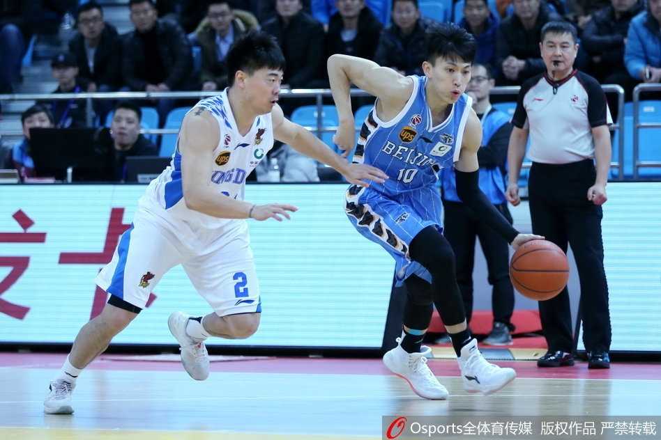 青岛队内线苏伟在篮下卡位要球，面对北京球员的贴身防守，他奋力跃起试图完成投篮