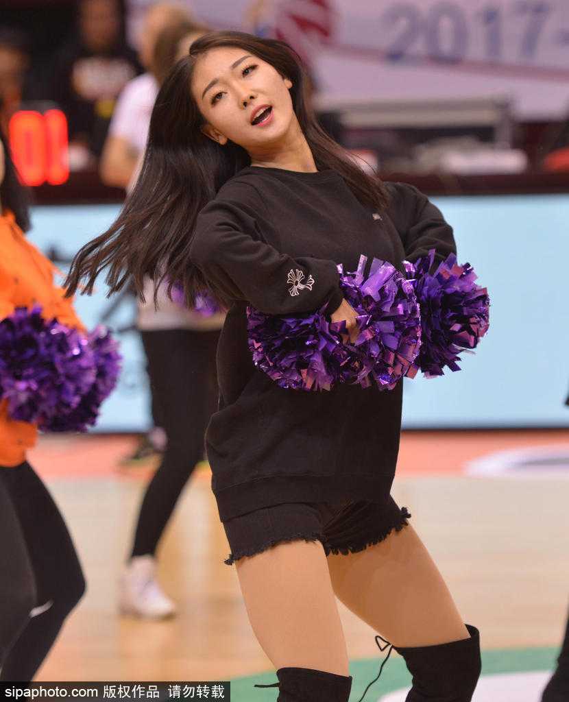 排练现场，一位扎着干练马尾的啦啦队员正在进行托举练习，她稳稳地站在队友们用手臂搭建的平台上，张开双臂保持平衡，脸上洋溢着从容与自信。