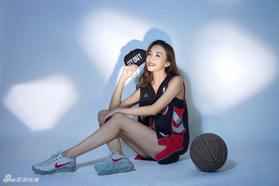 侧身回眸的瞬间，女孩的秀发随风飘起，紧身运动背心勾勒出优美的背部曲线，在绿荫映衬下宛如一幅动感时尚大片