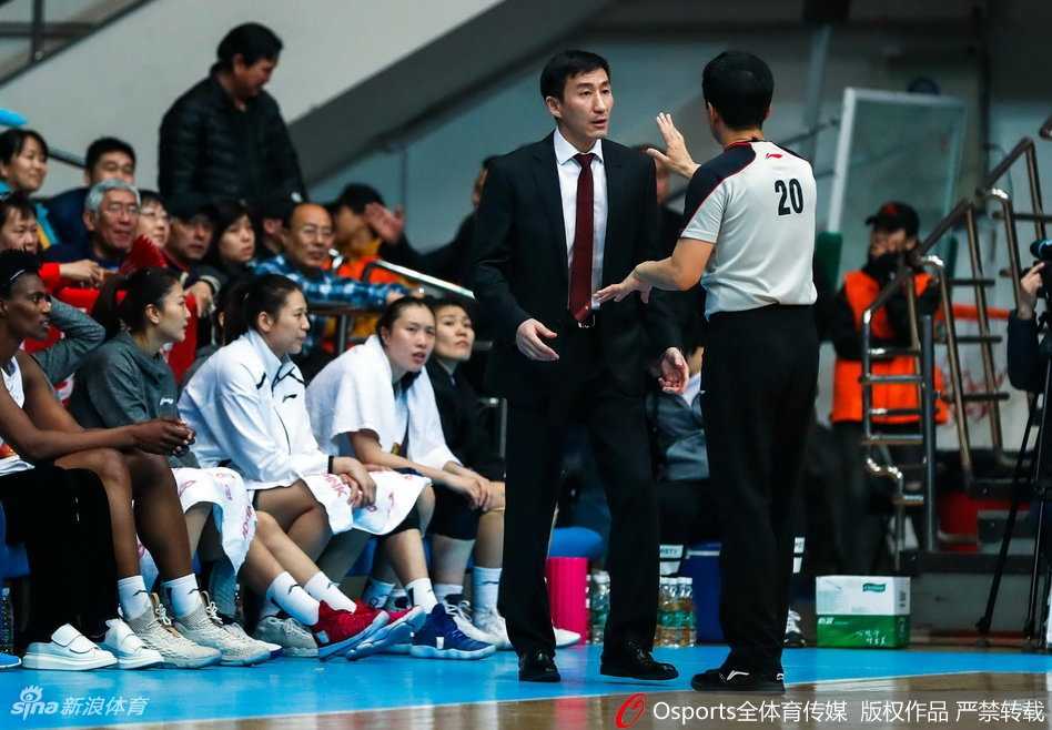 北京队主教练张云松在场边激情指挥，双手比划着战术手势，向场上队员传达着关键的防守策略与鼓励。