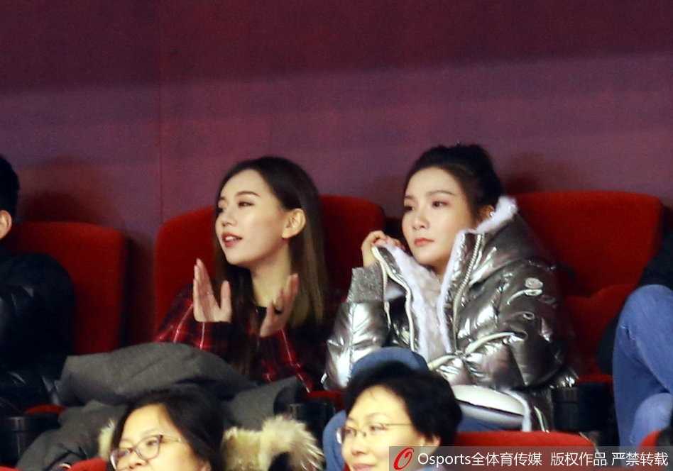 两人不经意间发现镜头，随即露出略带羞涩又惊喜的表情，手中拿着的同款手机壳在灯光下若隐若现