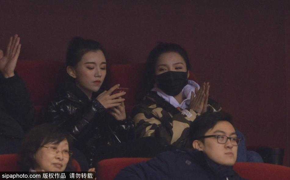 暖黄的灯光洒在睢冉妻子优雅的微笑上，她与身旁的丁彦雨航女友组成最美看台组合，两人轻松的神情似乎预示着场上山东队即将吹响胜利的号角。