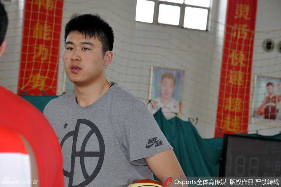 主帅李楠在训练间隙将丁彦雨航拉到一边，双手比划着跑位路线，小丁认真聆听，两人身后是挥汗如雨的队友们。