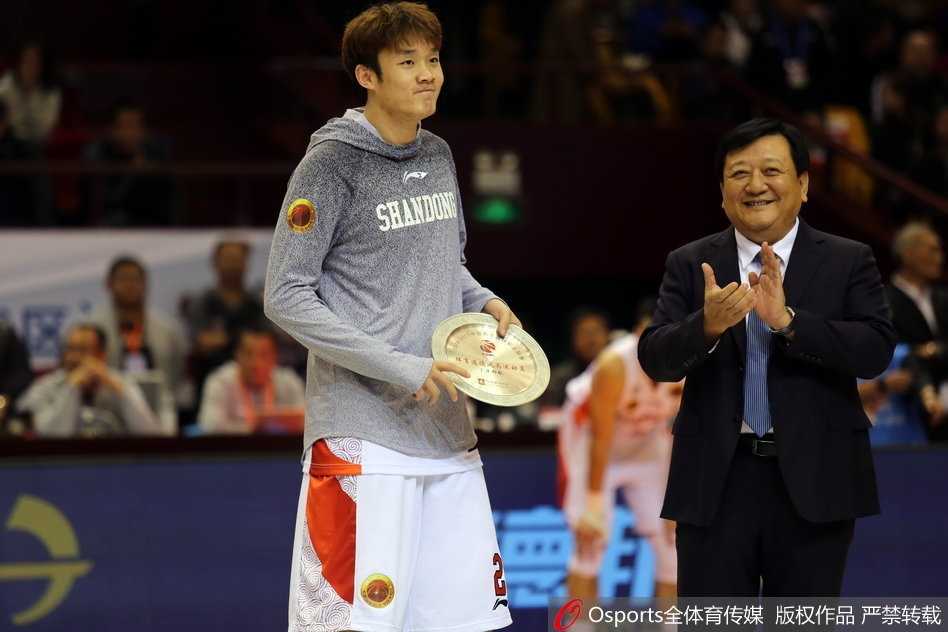 手捧鲜花和奖杯的丁彦雨航在颁奖仪式上腼腆而自豪地笑着，金色的纸屑从天而降，为他加冕时刻增添了几分梦幻的色彩。