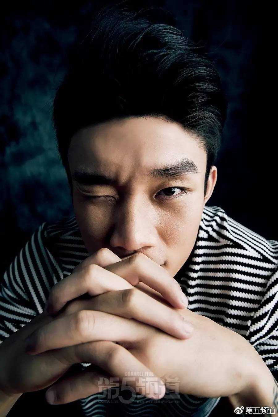 在篮球架背景的映衬下，丁彦雨航单手运球，眼神专注地盯着前方，身体线条充满力量感，将运动美学与时尚拍摄完美融合。