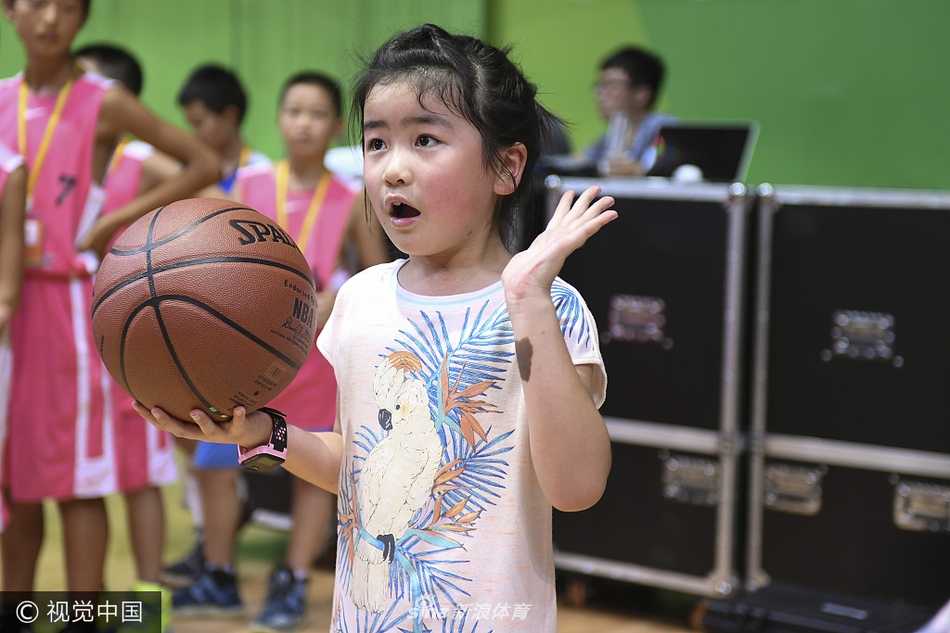 在人群的簇拥下，姚沁蕾双手抱球，神情自若地走过场地，虽然身边是来来往往的大人，但她就像一个小明星，自带光环。