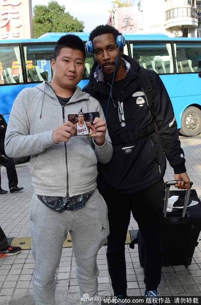 在拥挤的人群中，詹宁斯接过一支记号笔，眼神中透露出些许疲惫但更多的是对新赛季挑战的渴望，身旁的安保人员正努力维持着现场的热情秩序。