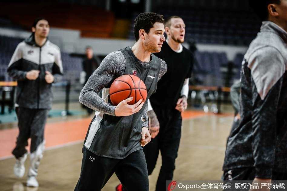 李秋平指导双手抱胸站在场边，神情专注地观看着弟子们的折返跑练习。