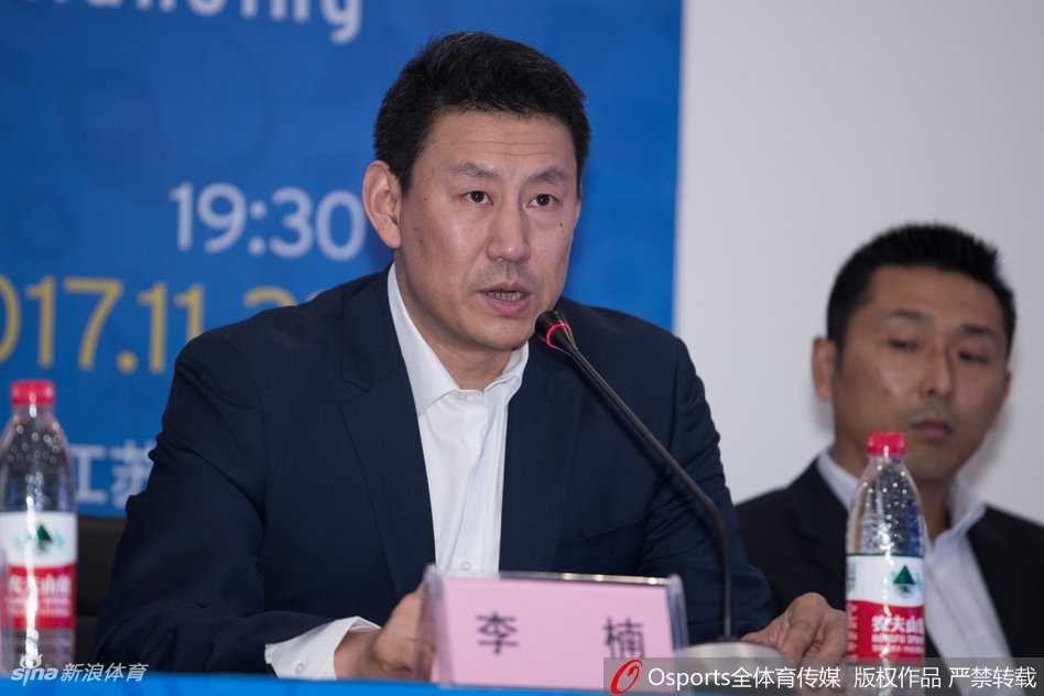 助理教练胡雪峰面带微笑倾听着主席台上的讲话，昔日的CBA传奇后卫如今以全新的教练身份亮相，胸前的证件见证着他从球星到教练的华丽转身。