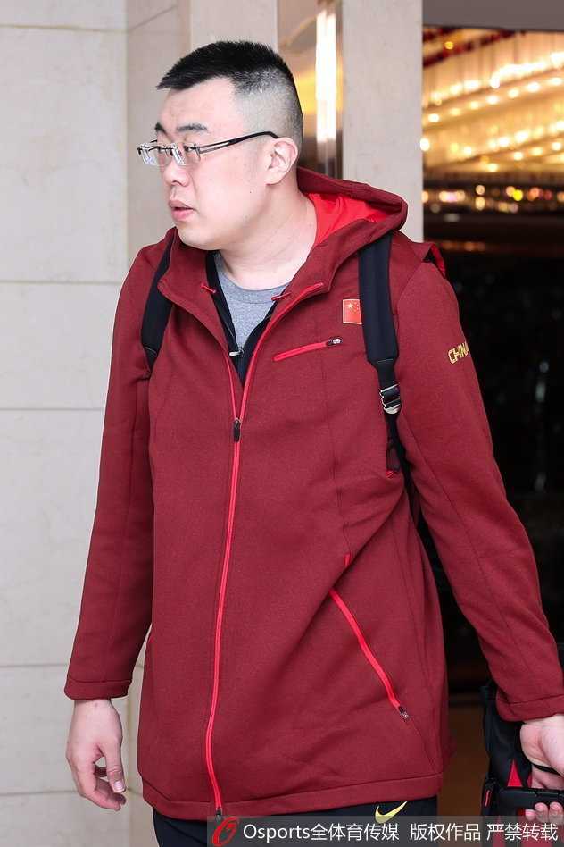 主帅杜锋手拿战术板走在队伍前列，眉头微蹙，眼神中透露出对即将开始的客场之旅的审慎思考与战术部署。