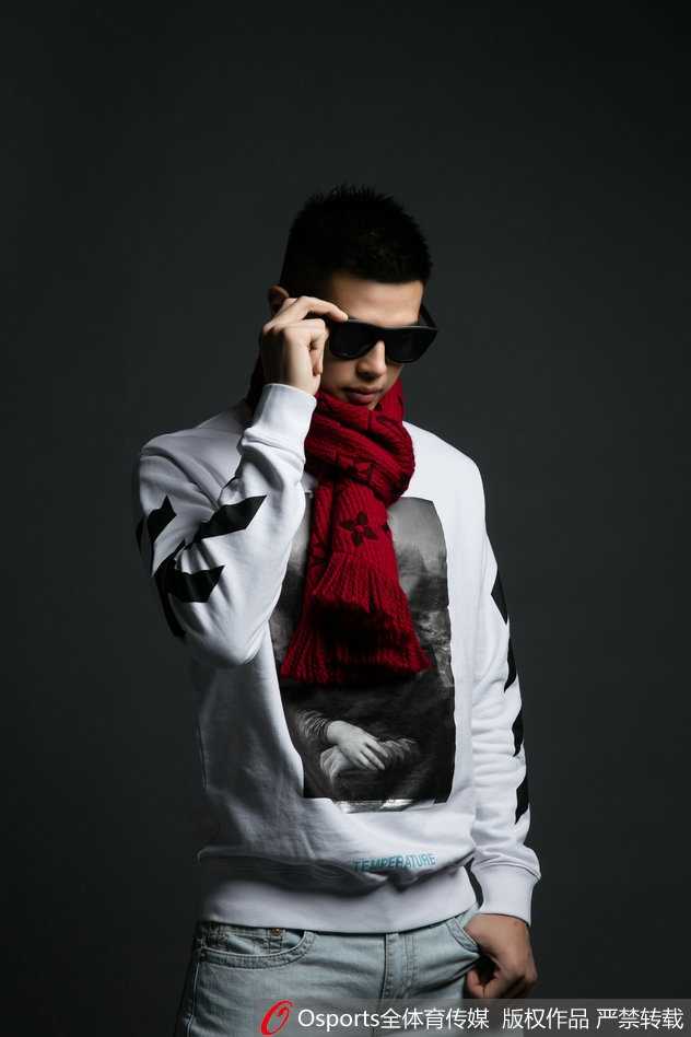 方硕倚靠在场边围栏，身着剪裁利落的西装外套，眼神深邃望向远方，气质儒雅。