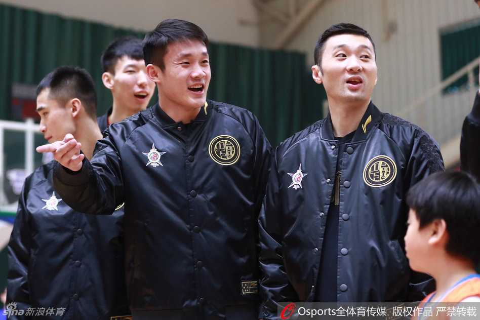 带着口罩的马布里蹲在孩子们中间，亲切地搂着两位小球迷的肩膀合影，眼神中满是慈爱