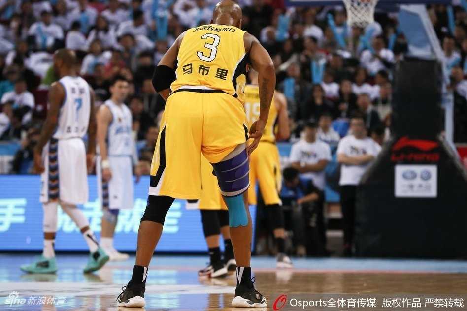 马布里持球强行突破，面对两名防守球员的包夹封堵，他咬紧牙关腾空而起，身体在空中扭曲成一张弓，奋力将球抛向篮筐。