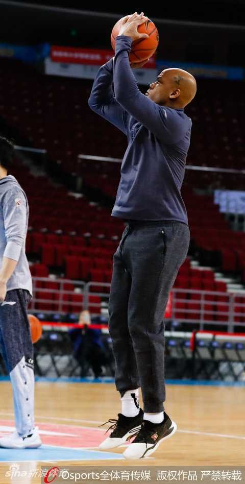 马布里双手持球置于腰间，眼神如炬望向远方，背景虚化的看台座椅仿佛静默的观众，等待着夜晚的喧嚣只为一人响起。