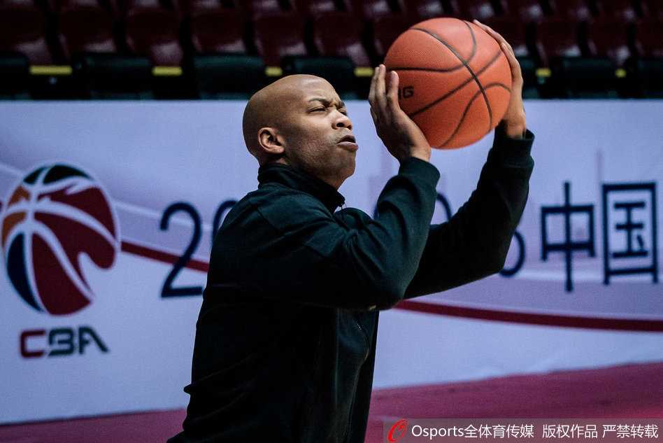 全体球员围拢在一起进行训话，马布里站在圆心位置挥舞着手臂，紫金色的北控训练服在灯光下格外显眼，周围的队友们神情专注，团队凝聚力在这一刻尽显无遗。