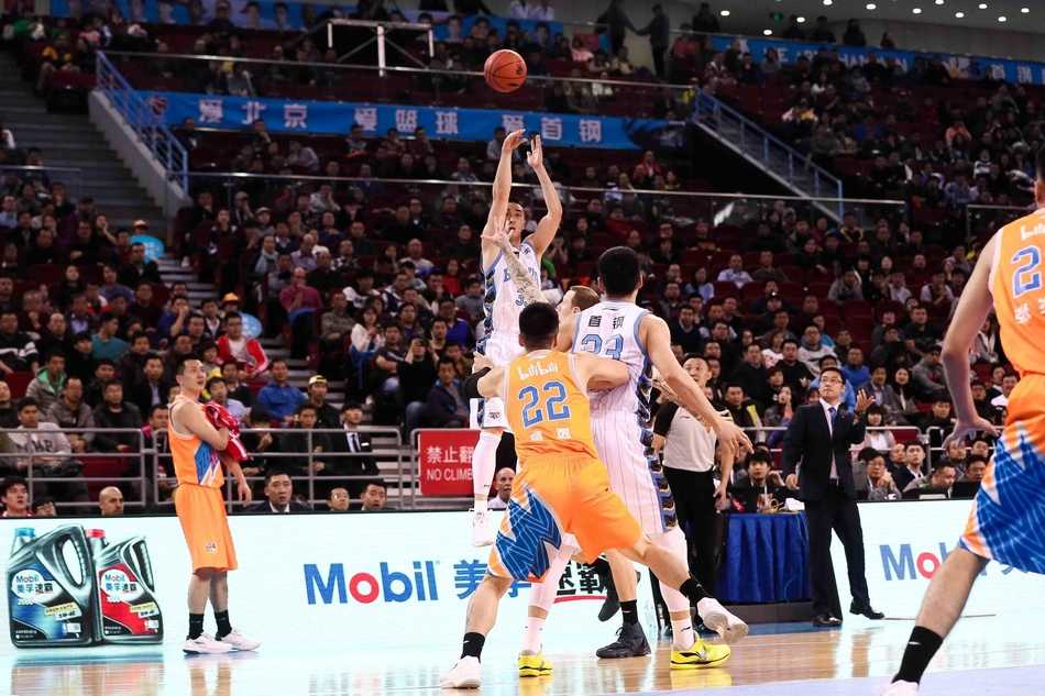 汉密尔顿高高跃起单手劈扣，身体在空中绷成一张弓，上海队防守球员只能无奈仰望这记势大力沉的灌篮。