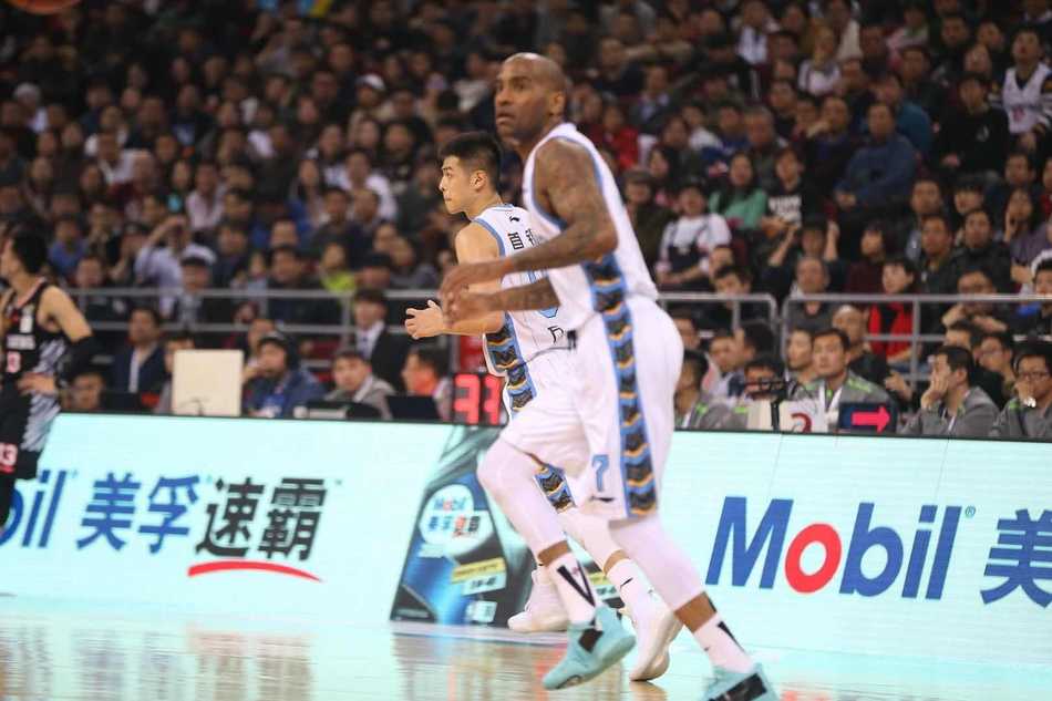 外援杰克逊在高速行进中突然急停跳投，他灵动的身影与看台上如海洋般的白色助威服交相辉映，构成一幅充满动感的画面。