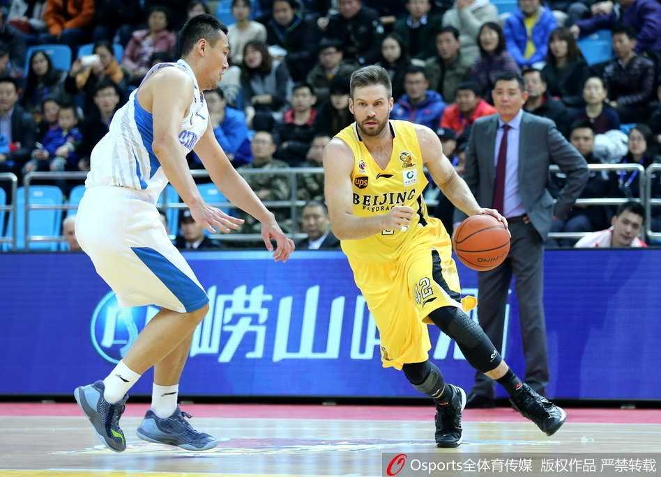 青岛队外援吉布森在重重包围之下强行突破，他眼神坚毅，试图用一记高难度的抛射穿越北控队阿巴斯的遮天大帽，为球队挽回一丝颜面。