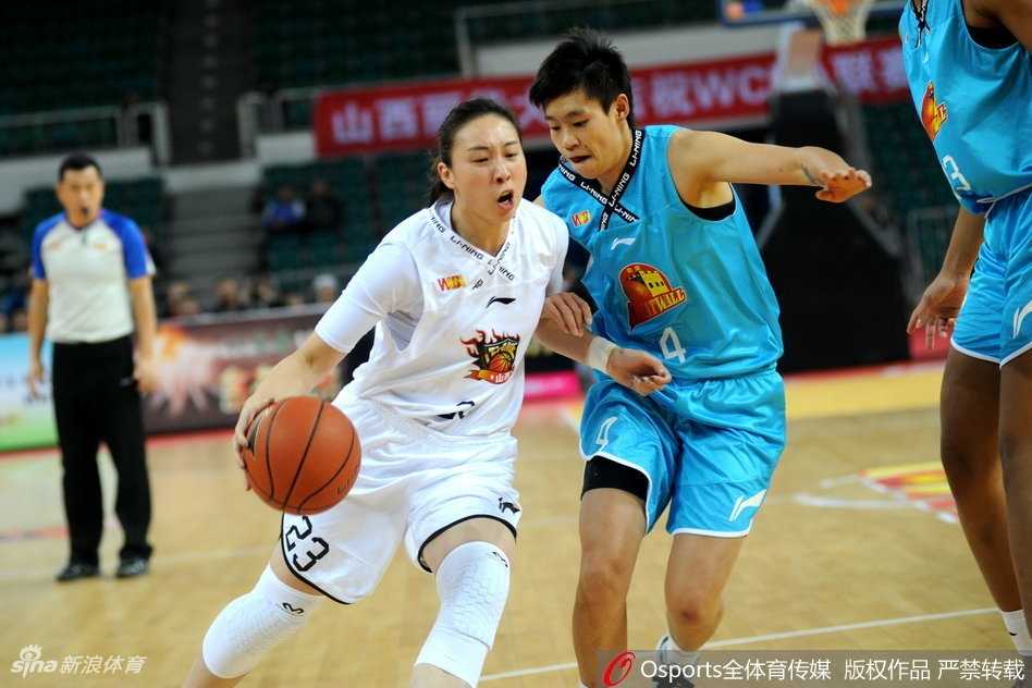 山西队后卫赵志芳面对北京队的紧逼防守，压低重心巧妙运球突破，试图撕开对手的防线为队友创造机会。