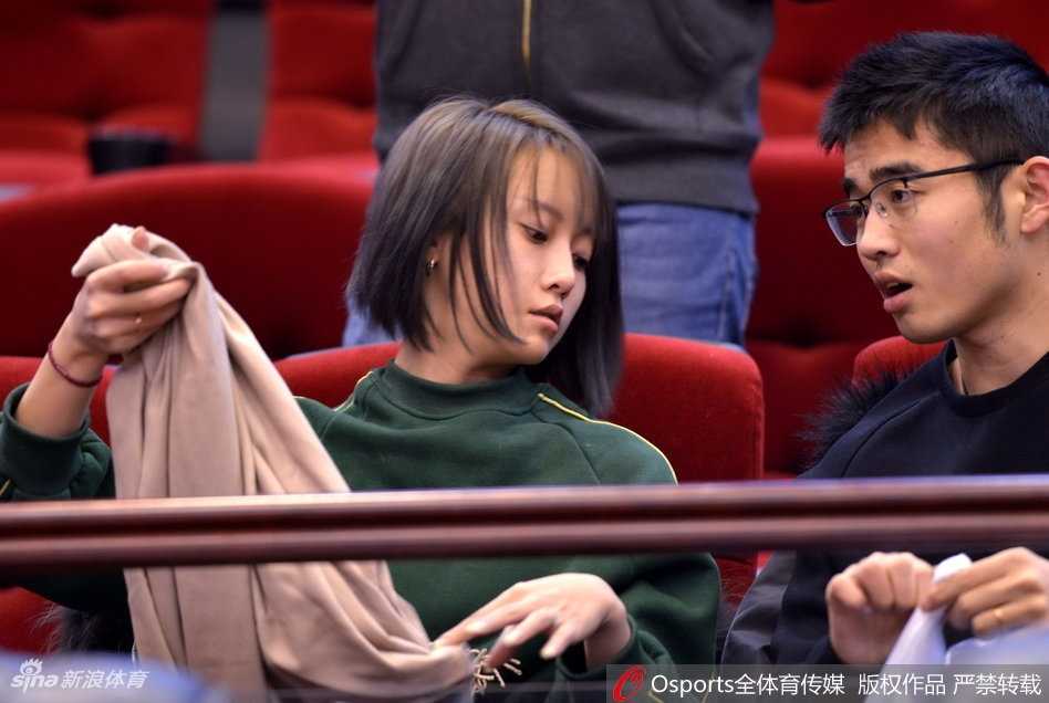 一位妆容精致的女球迷，脸上画着山东队的助威彩绘，在人群中开怀大笑，仿佛已经预见到了主队的胜利。