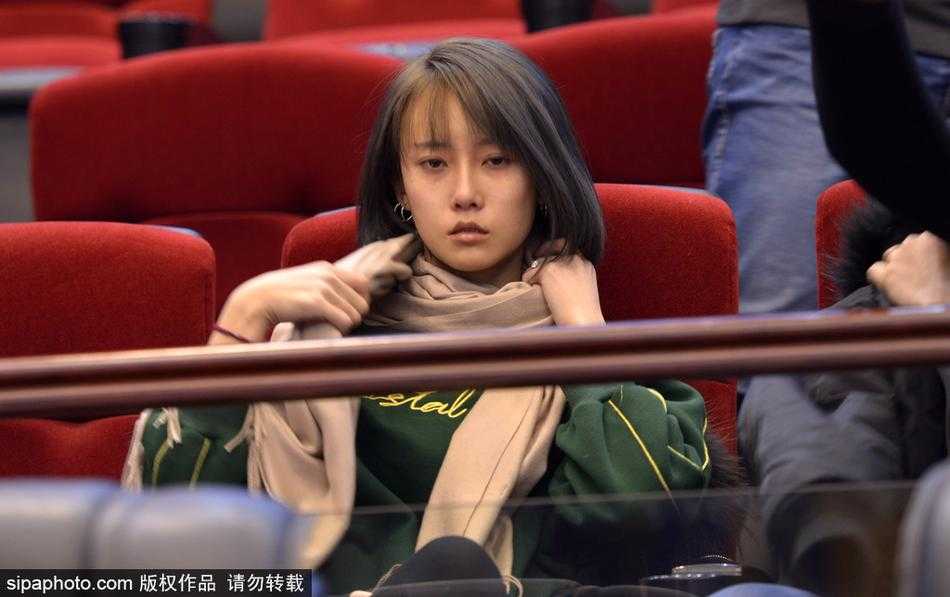 赛后，一名身材高挑、穿着时髦皮草的美女球迷在人群中回眸，她手中拿着庆祝的充气棒，脸上带着满意的微笑，似乎还沉浸在刚才那场惊心动魄的逆转大战中。