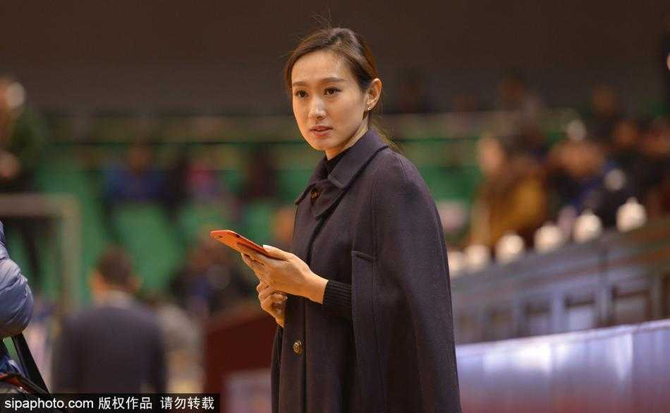 全景镜头扫过座无虚席的山东高速球馆，一名长发披肩、妆容精致的美女球迷恰好在人群中抬头，清澈的眼眸中倒映着球场上的光芒，仿佛在与场上球员进行无声的对话。