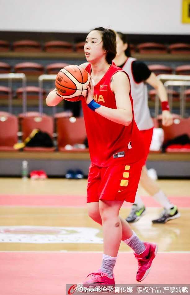 许利民指导手持战术板，正在为内线球员李月汝讲解禁区内的卡位要诀，眼神中充满期待。