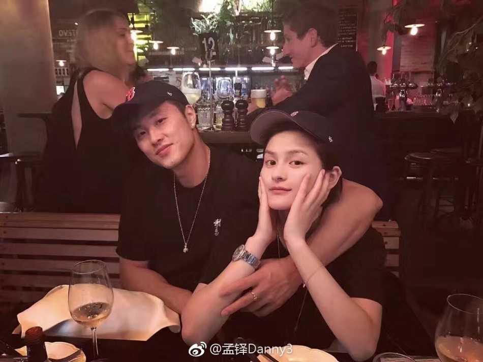 孟铎与女友身着休闲装，在户外留下温馨合影，两人举手投足间充满默契，展现了运动员情侣的活力与柔情。