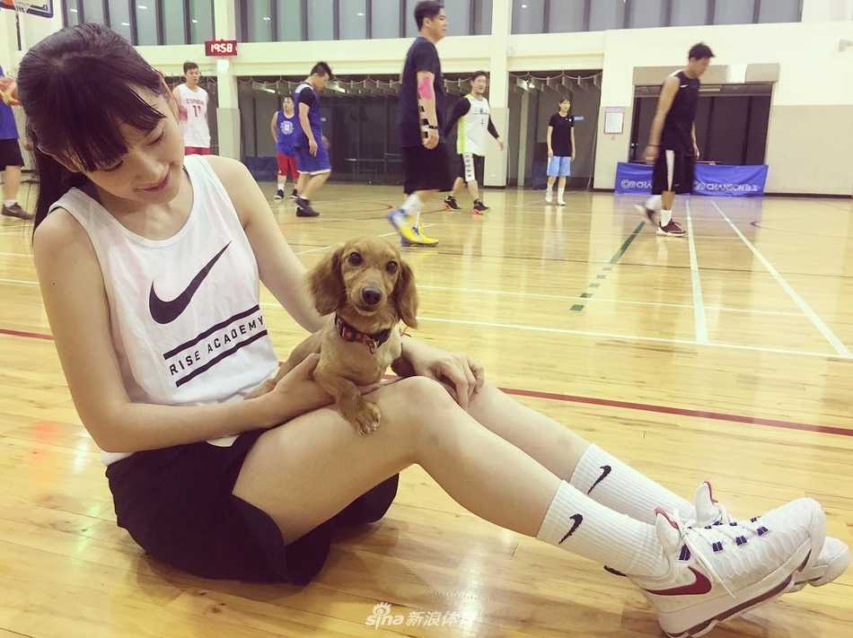 阳光穿过发丝，洗菜在球场边展露标志性的甜美笑容，清纯气质如同邻家学妹。