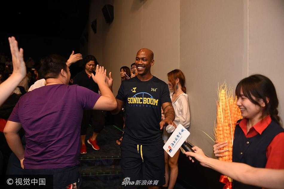 马布里双手插兜，酷劲十足地站在影厅的过道上与影迷互动。他身后是巨大的电影海报，现场灯光璀璨，气氛如同一个盛大的篮球派对。