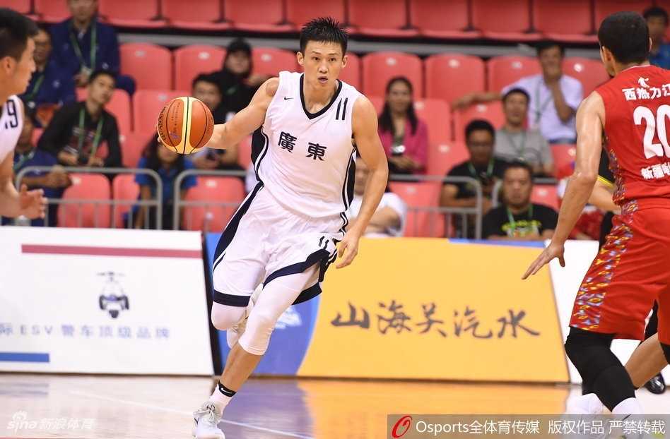 广东队长周鹏在防守端滑倒后坐在地上，无奈地摊开双手，身后的新疆球员正庆祝得分