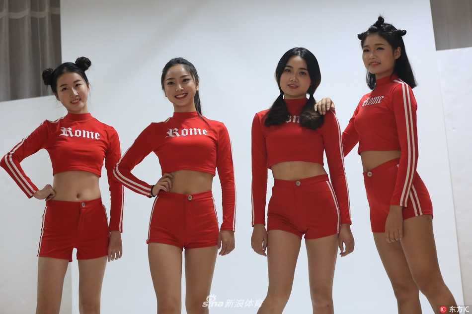 两名篮球宝贝在走廊里相视而笑，她们身着休闲的校园风装扮，修长的美腿在短裤下格外抢眼，亲密的互动流露出姐妹间真挚的友谊和青春的无限美好。