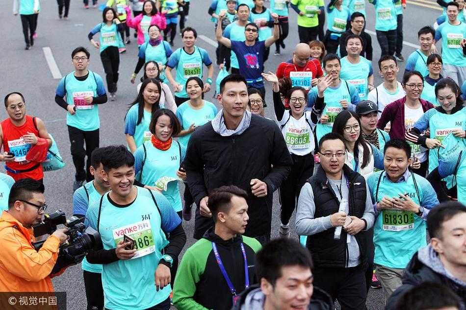 广东男篮的队员们集体行进在马拉松赛道上，他们高大的身影在人群中格外醒目，正享受着难得的赛场外相聚时光