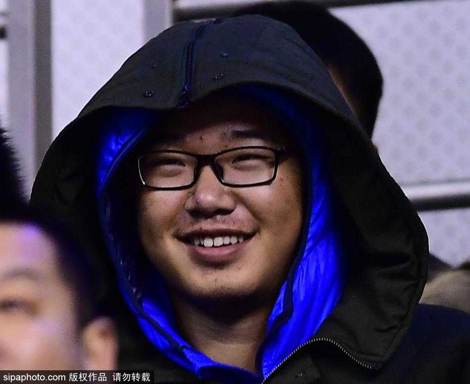 一位年轻女球迷将羽绒服的帽子紧紧系在脸颊上，只露出一张冻得微红的脸，她的眼神专注地望向赛场，紧握应援棒的手缩在袖口里，那份在严寒中依然不减的观赛热情，让人动容。