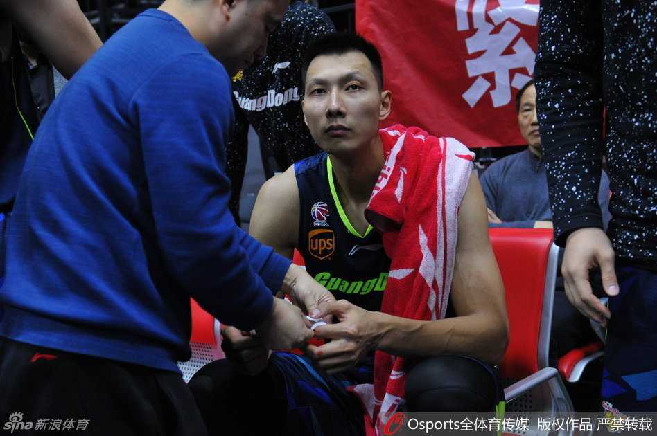 隊醫正在進行包紮，阿聯低頭看著傷口，汗水從額頭滑落，眼神疲憊而複雜。