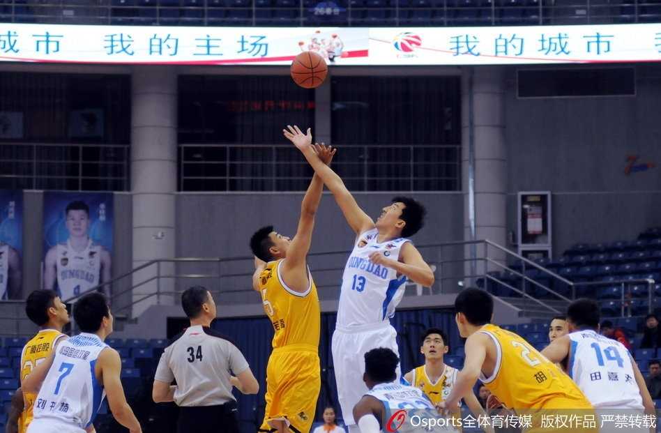 年轻的胡金秋高举双臂，在青岛队内线群中精准地将球放入篮筐，展现出新生力量的锋芒