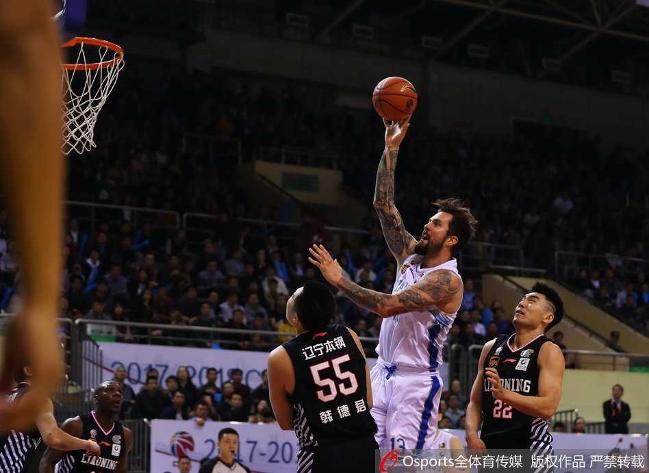 江苏老将陈磊在比赛中坚定地执行战术，尽管面对年轻力壮的防守者，他依然毫无畏惧，奋力将球传给位置更好的队友。