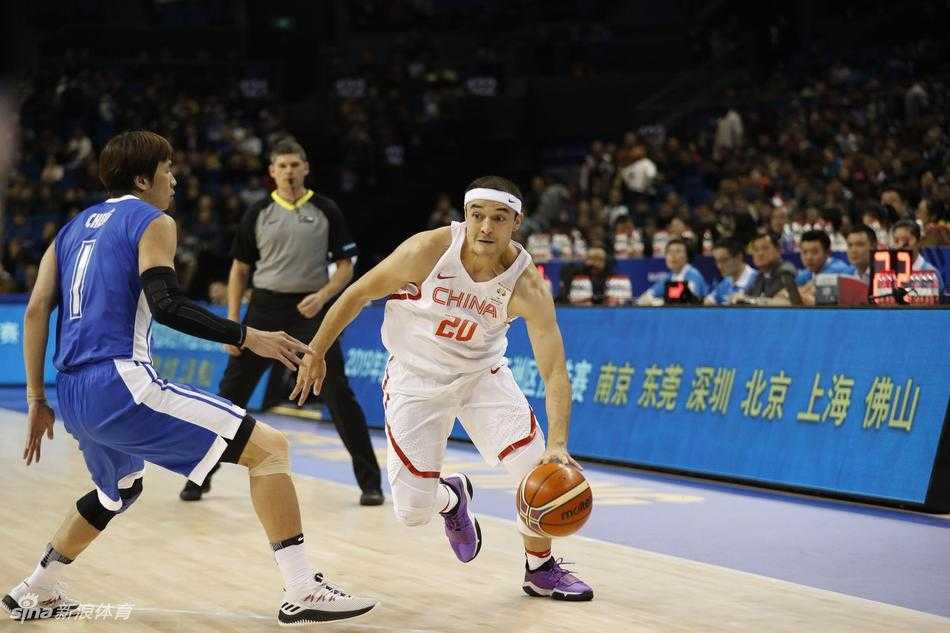 赛后，主教练李楠在场边接受采访，表情严肃而专注，背景是兴奋庆祝胜利的队员们，这一幕凝聚了教练的运筹帷幄与球员的激情释放。